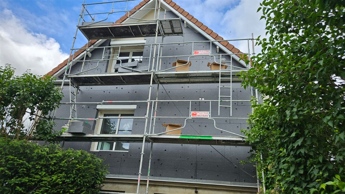 Façade en cours d'isolation par l'extérieur, sous échafaudage