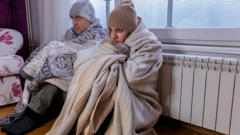 Un couple qui a froid à cause d'un manque d'isolation thermique dans leur maison
