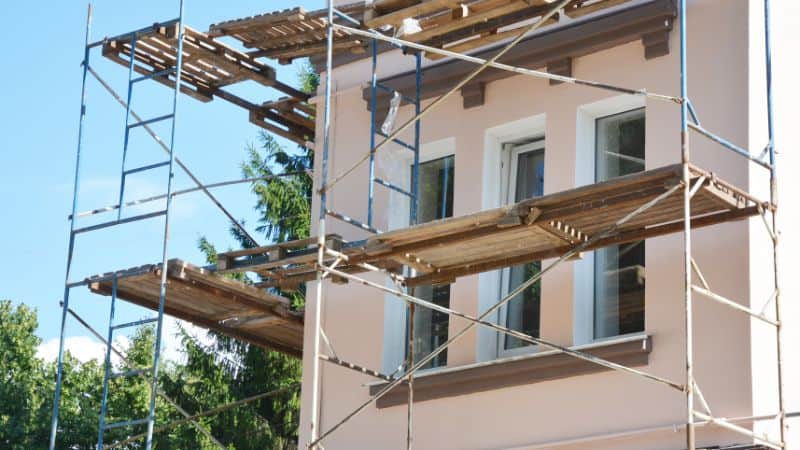 Une maison avec des échafaudages nécessaires pour des travaux de ravalement
