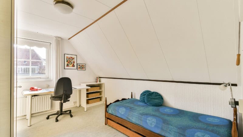 Un comble transformé en chambre après les travaux de toiture d'un couvreur