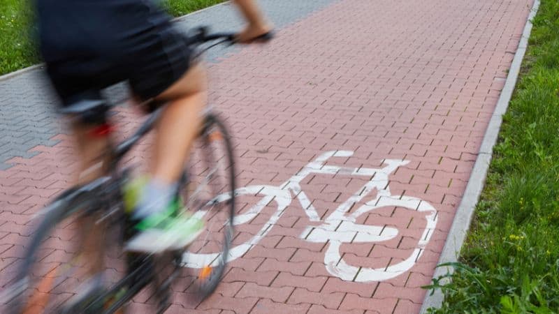 Un cycliste venant de passer devant un portail d'une maison