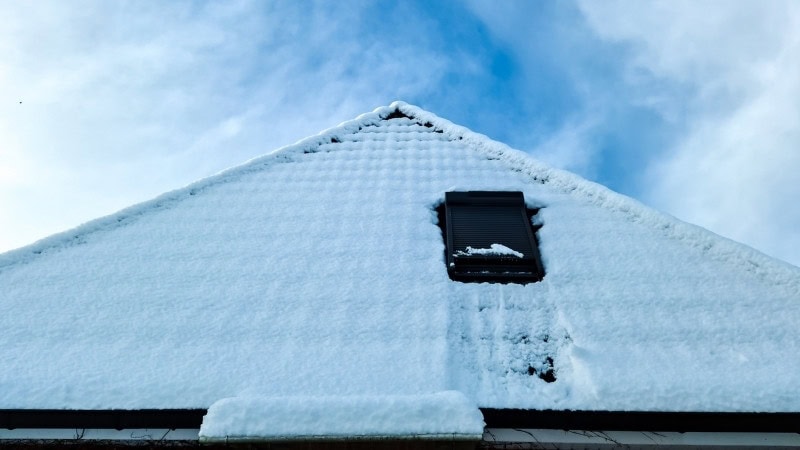 Une fenêtre de toit velux avec un volet roulant qui protège du froid en hiver