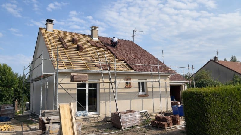 Un couvreur à Pontoise intervenant sur une maison pavillonnaire