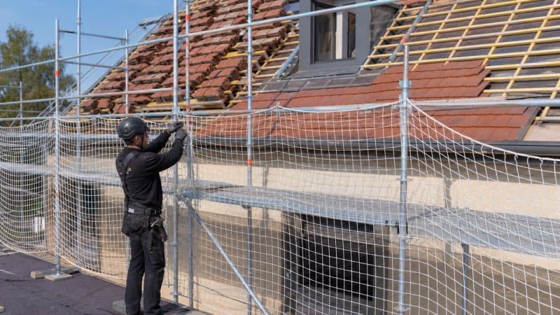 Un professionnel en toiture qui fait la préparation d'un chantier de toiture