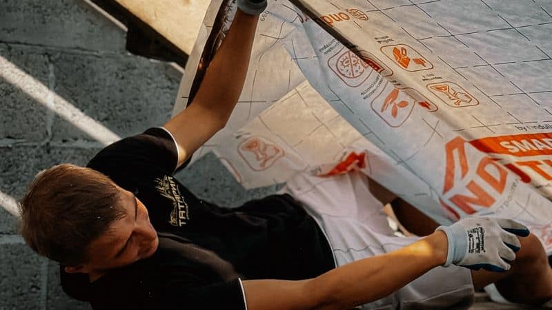 Un artisan qui isole une toiture par l’intérieur